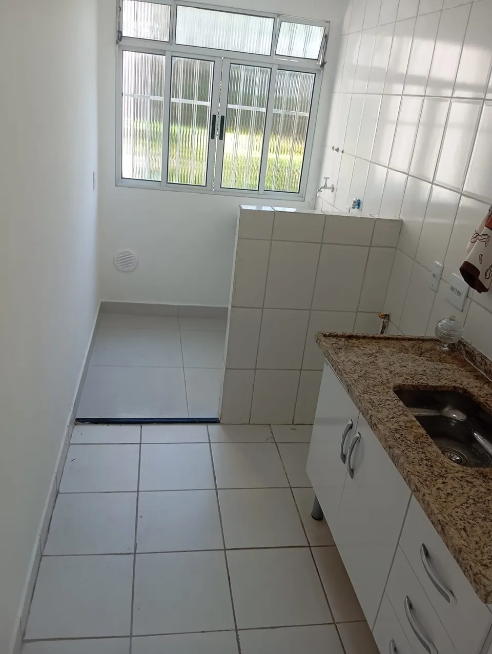 Cozinha com bancada de granito e janela
