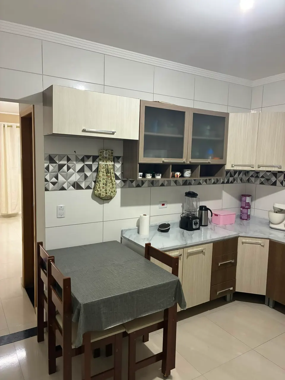Cozinha com armários aéreos e mesa